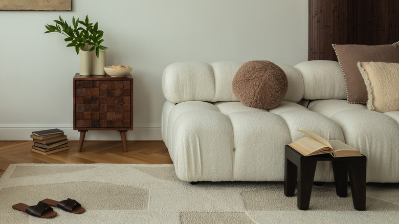 A modern neutral living room with a small cabinet used as a side table