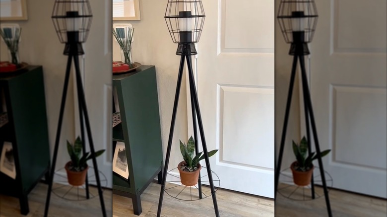 A DIY solar light plant stand with a small potted plant on the lower shelf
