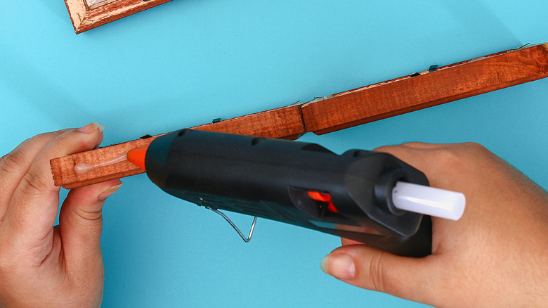 Person using a hot glue gun for a project