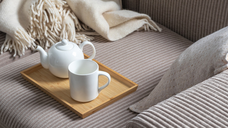 Sofa tray on couch with teapot and tea cup