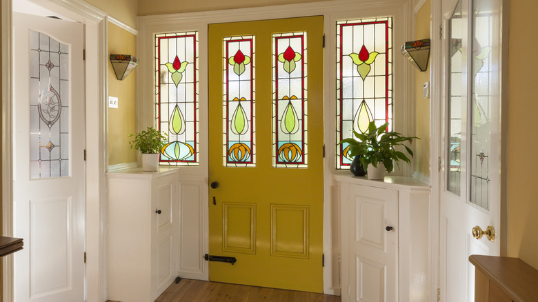 A yellow front door with a modern stained glass window