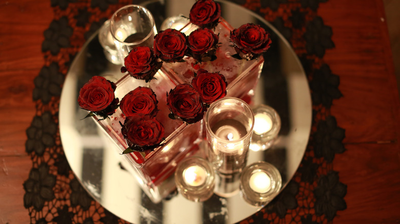 A flower arrangement sitting on a mirror