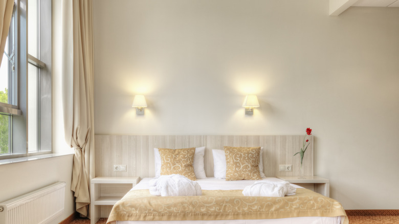 Bedroom with sconces on the wall in the background