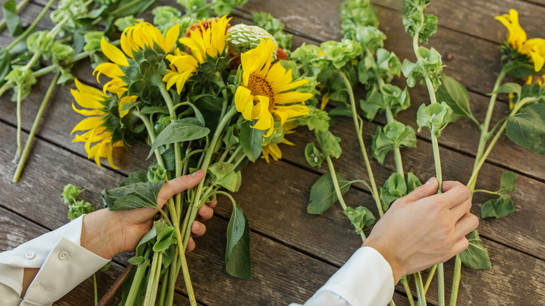 Hands selecting flowers for a floral display