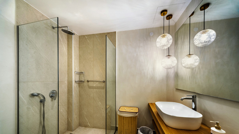 Lighting hanging sconces in neutral colored windowless home bathroom