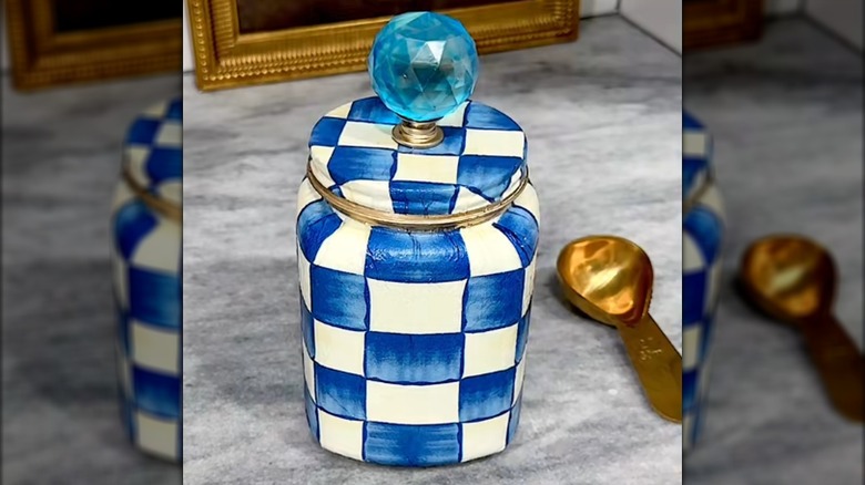 A blue and white checked jar made from a Dollar Tree container mimics designer style.