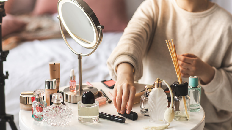 Person sitting in front of cluttered vanity