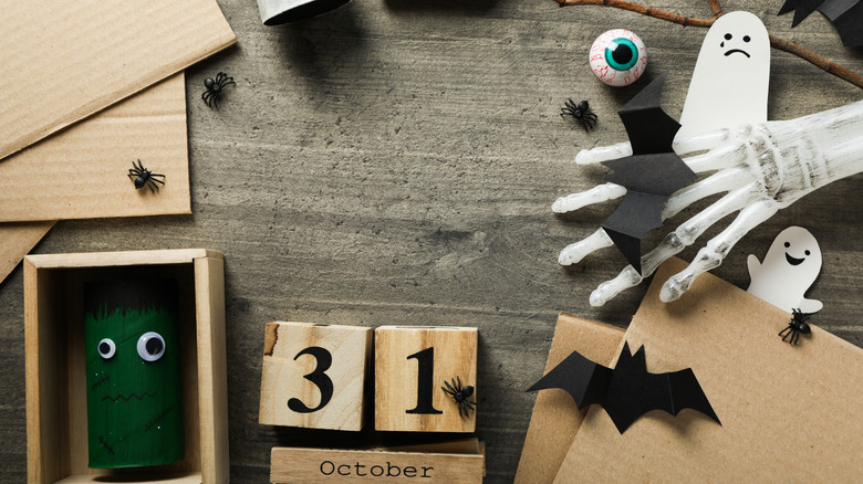 Creepy Halloween decorations and handmade crafts sit on a wooden table