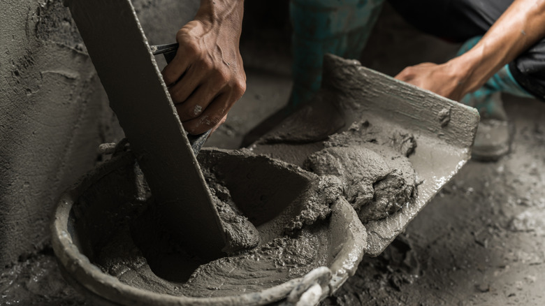 Hands plastering using concrete.