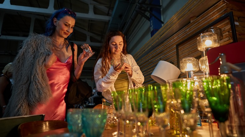 Two people shopping for thrifted glassware