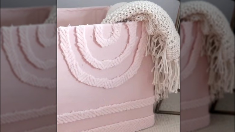 A DIY pink cloth-covered box holds a blanket.