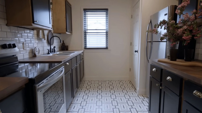 A small kitchen with patterned floor tile and herringbone butcher block counters