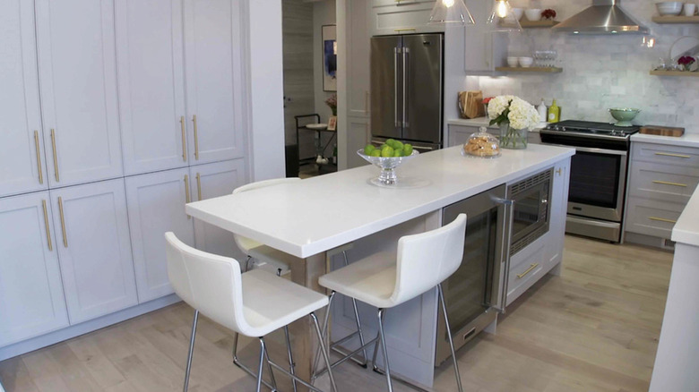 A kitchen with light gray floors and white cabinets