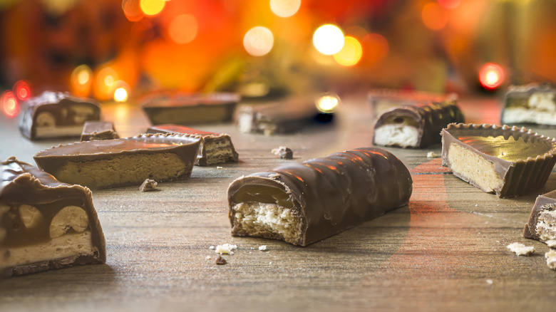 Halloween chocolate bars on a table with orange lights in the background