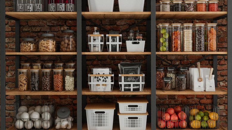 Wall of shelving filled with canned foods, baskets of fruit, and other pantry items.