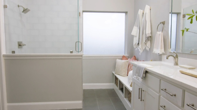 A neutral bathroom with a storage bench