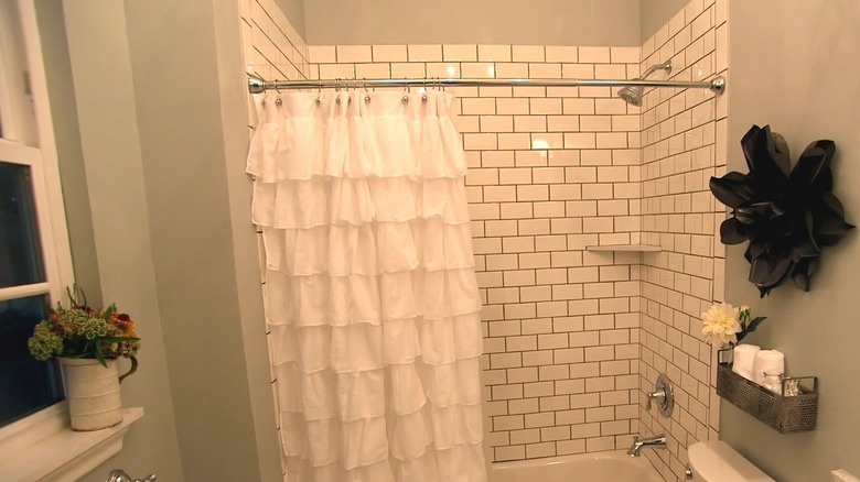 white, ruffled shower curtain in small bathroom