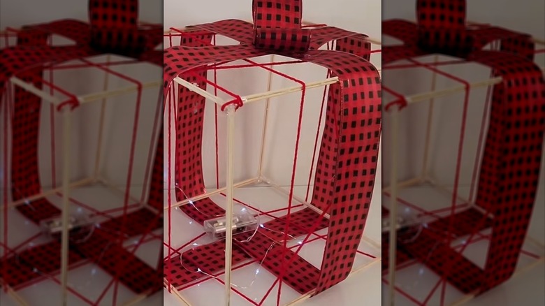 3D dimensional present decor with white lights created from ribbon and skewers