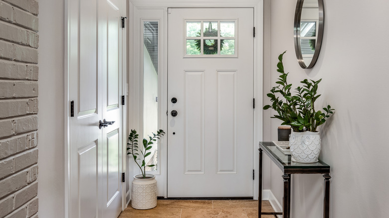 home entryway with hardwood flooring, white door with windows and plants