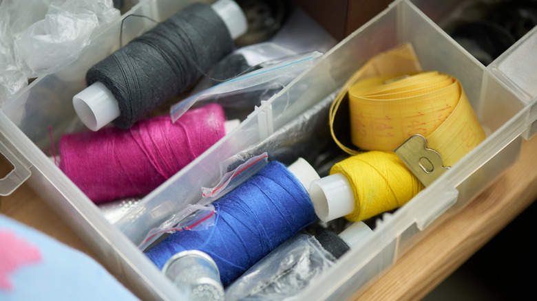 Sewing materials in plastic containers at the thrift store