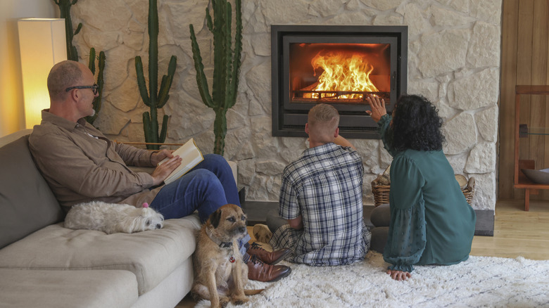 People enjoying a fire in a fireplace