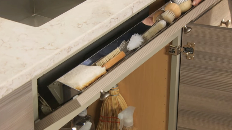 Martha Stewart displays a tilt-out tray she added into a kitchen she helped design.