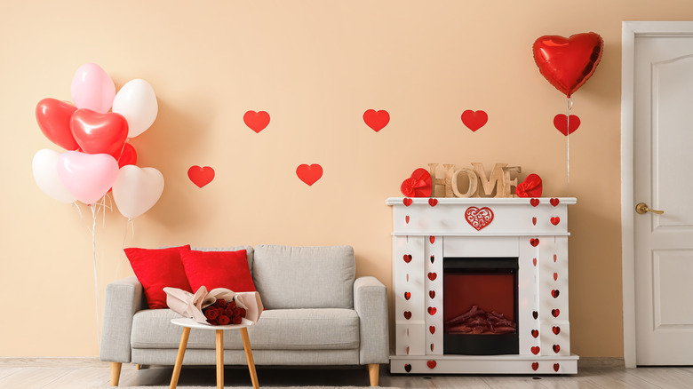 A living room decorated with heart balloons, stickers, and flowers