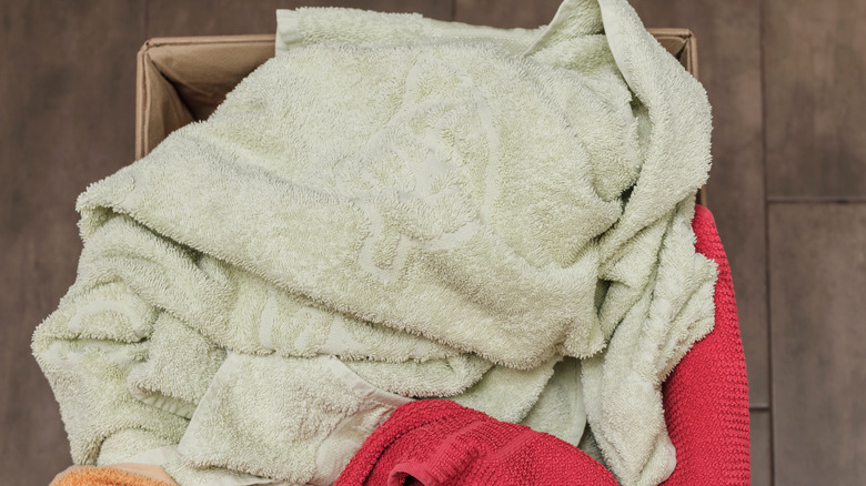 A cardboard box holds old washcloths, hand towels, and bath towels