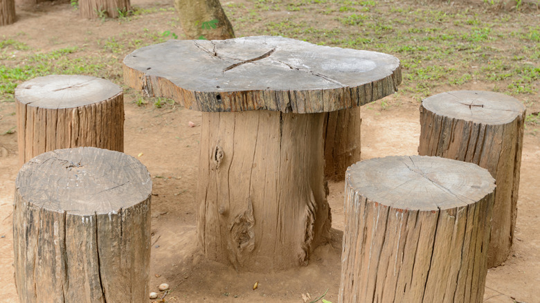 A wooden chair and table set made from tree stumps