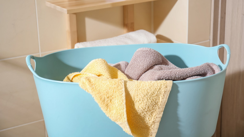 Unfolded towels in a laundry basket in a bathroom