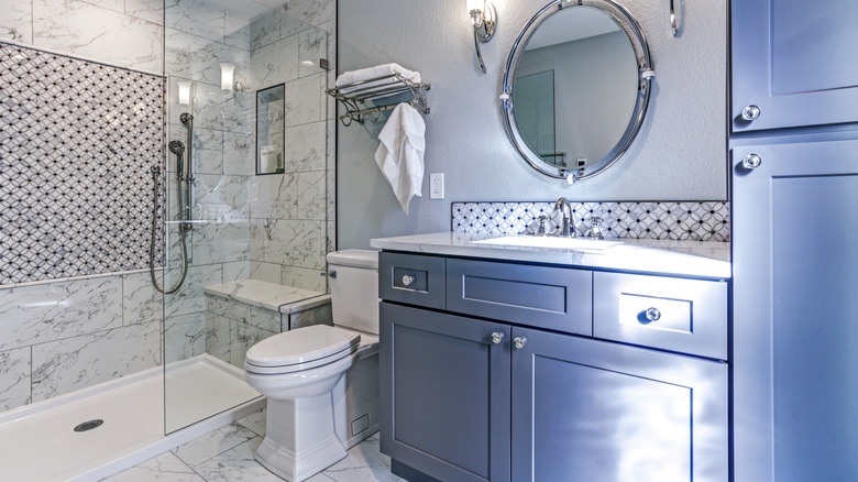 Blue vanity with glass door knobs in bathroom