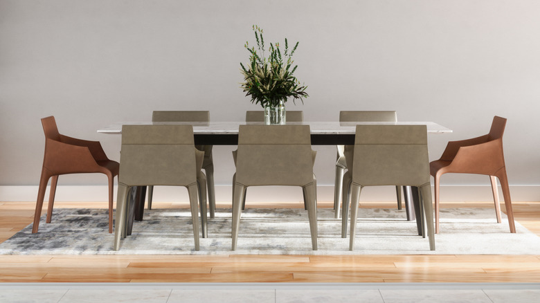 A dining table with six normal gray tables around it and two reddish brown chairs on either side as head chairs
