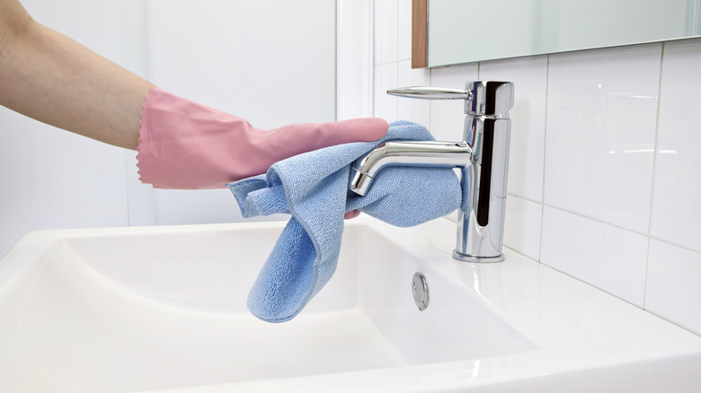 Person cleaning faucet