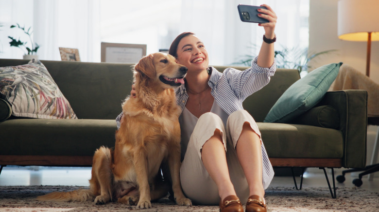 Woman taking a selfie with golden retriever dog