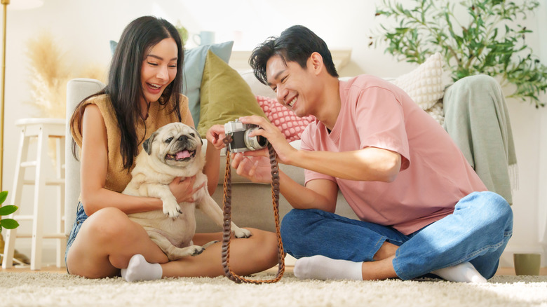 A couple takes photos of their dog