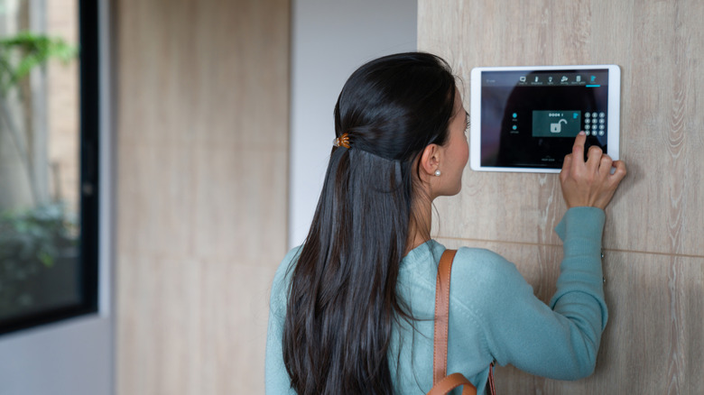 A person pressing buttons to unlock their smart home system