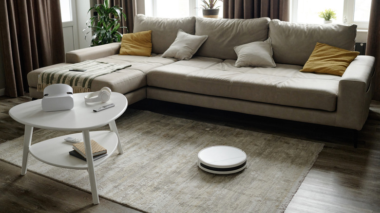 A living room with a smart robot cleaning the rug