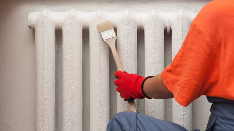 person painting radiator 