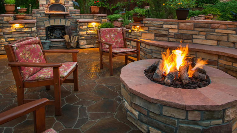 A typical stone fire pit in an attractive backyard