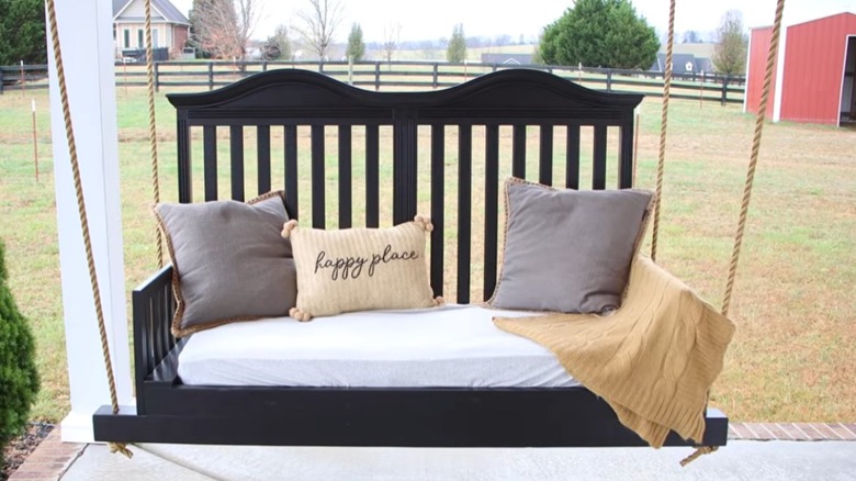finished project of DIY porch swing from wood baby crib