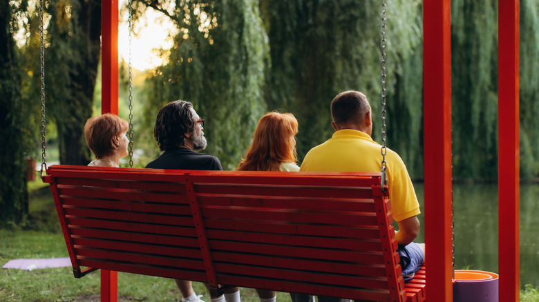 group of people sitting on porch swing and enjoying view