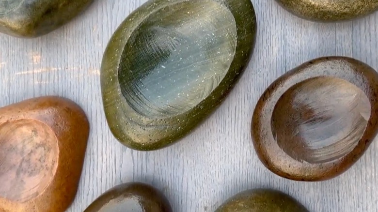 A selection of bowls made out of large river stones with depressions carved into the center.