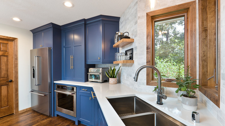 A kitchen with marble countertops and tile backsplash.