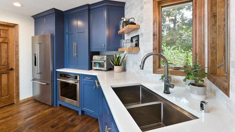 A kitchen with marble countertops and tile backsplash.
