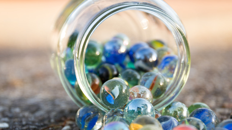 A jar of colorful marbles outdoors