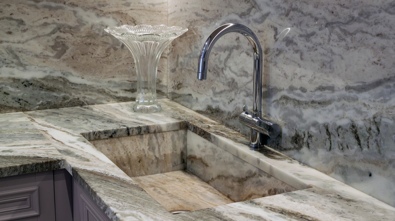 A marble sink with a stainless steel faucet