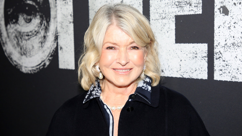 Martha Stewart stands in front of a black backdrop