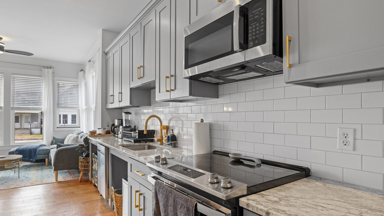 Modern kitchen with sleek stainless steel appliances, countertops, and wooden flooring.