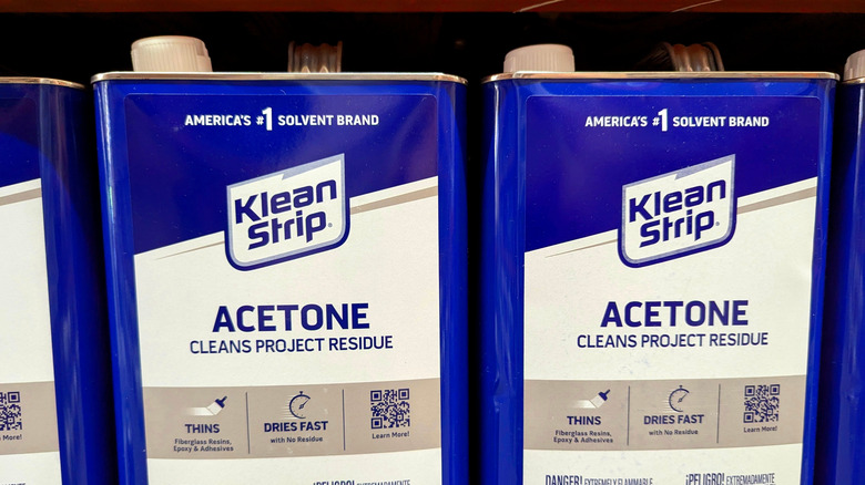 Bottles of acetone on a shelf.