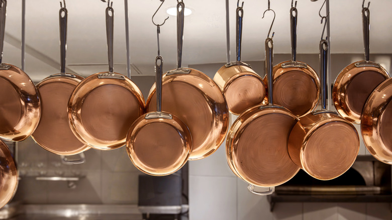 Copper pots and pans hanging in a kitchen.